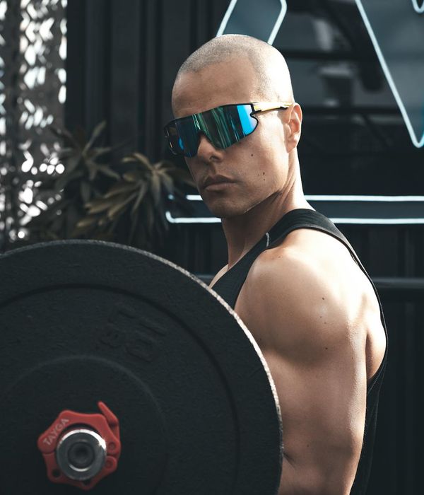 Man in a focused power stance against a calm background.